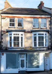 a brick house with white windows and a balcony at Flat 1, Church House in Ilfracombe