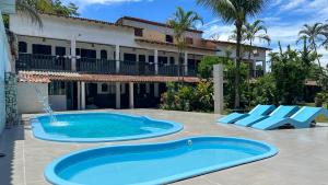 una piscina frente a un edificio con complejo en Alfa Mar Pousada, en Abraão