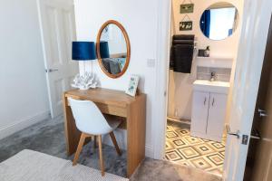 a bathroom with a desk and a mirror and a chair at Flat 1, Church House in Ilfracombe