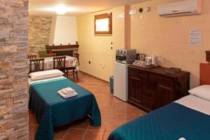 una camera d'albergo con due letti e una cucina di Alloggio Gladiolo a Monticchio