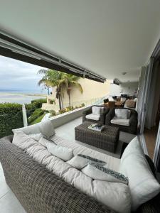 a living room with a couch and chairs and the ocean at Holiday Villa with stunning views near beach. in Plettenberg Bay