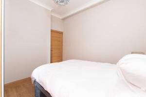 um quarto branco com uma cama e um closet em Newington em Edimburgo