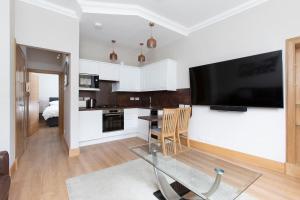 a kitchen with a large flat screen tv on a wall at Newington in Edinburgh