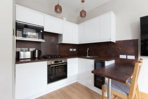 a kitchen with white cabinets and a wooden table at Newington in Edinburgh