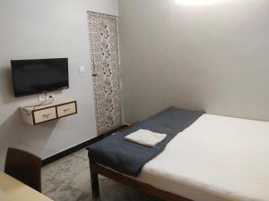 mały pokój z łóżkiem i telewizorem z płaskim ekranem w obiekcie Sri Kavimany Residency w mieście Kālapettai