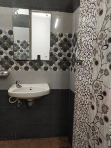 W łazience znajduje się umywalka i lustro. w obiekcie Sri Kavimany Residency w mieście Kālapettai