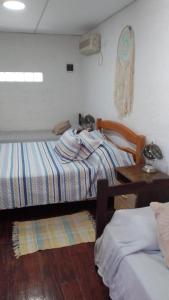 a bedroom with two beds and a table and a desk at La Baquiana 2 in Mercedes
