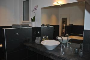 La salle de bains est pourvue d'un lavabo et d'un grand miroir. dans l'établissement Villa DUXCAAR Avel Mor, à Guissény
