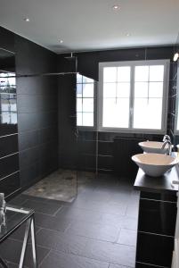 ein Badezimmer mit zwei Waschbecken und einer Glasdusche in der Unterkunft Villa DUXCAAR Avel Mor in Guissény