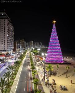 un gran árbol de Navidad en una playa por la noche en Unitá Praia Grande Boqueirão, en Praia Grande