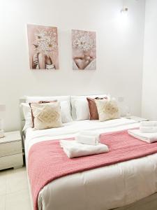 una camera da letto con un grande letto bianco con due dipinti sul muro di La casa di Alessia nel centro di Como - Alessiatravelling a Como