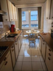 a kitchen with a table and a dining room at Appartement Parc Forestier 3-4 personnes in Brussels