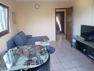 a living room with a couch and a tv at Apartment D&J in Mošćenička Draga