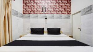 1 dormitorio con cama blanca y almohadas negras en Pyrenees Homestay, en Agra