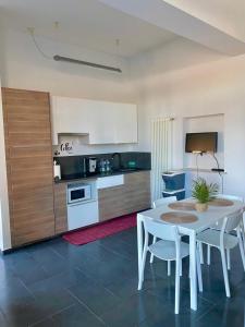 a kitchen with a white table and white chairs at *Love'n fly apartament * Airport- Ducati in Bologna