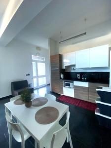 a kitchen with a white table and chairs in a room at *Love'n fly apartament * Airport- Ducati in Bologna