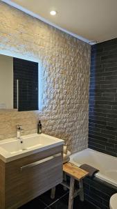 een badkamer met een wastafel en een bad naast een bad bij LA BELLE IDEE in Nokere