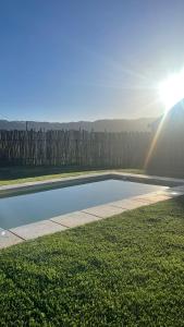 a pool in the grass with the sun in the background at La Pasiva in Villa Giardino