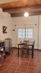 a dining room with a table and chairs and a kitchen at LA MAISON in Lozano