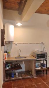 a kitchen with a counter with a sink and a microwave at LA MAISON in Lozano +6 photos