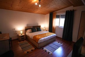 - une chambre avec un lit, une fenêtre et 2 tapis dans l'établissement Grandpa House-Attic App 4, à Tirana