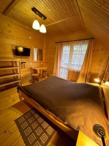 sypialnia z dużym łóżkiem w drewnianym pokoju w obiekcie Бавор w Jaremczach