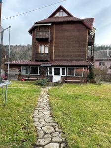 una grande casa in legno con un sentiero in pietra davanti di Бавор a Jaremče
