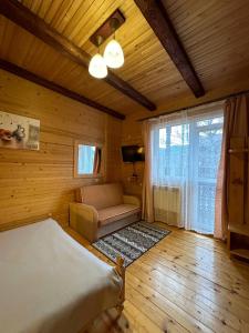 sypialnia z łóżkiem, kanapą i oknem w obiekcie Бавор w Jaremczach