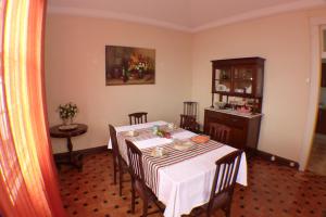 une salle à manger avec une table, des chaises et une armoire dans l'établissement Casa da Avó Benvinda, à Funchal
