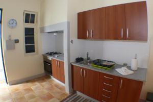 フンシャルにあるCasa da Avó Benvindaの木製のキャビネットとカウンタートップを備えたキッチン +7枚の写真