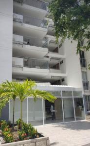 un edificio con una palmera delante de él en Apartamento Rodadero Santa Marta 902, en Santa Marta