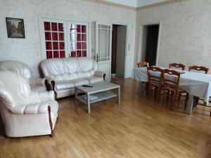 sala de estar con muebles blancos y mesa en Maison chaleureuse, en Saint-Jean-dʼAngély