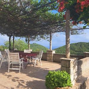 eine Terrasse mit Stühlen und einem Tisch mit Aussicht in der Unterkunft Holiday house Bore in Babino Polje