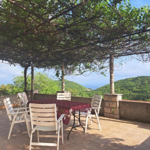 einen Tisch und Stühle auf einer Terrasse mit Aussicht in der Unterkunft Holiday house Bore in Babino Polje