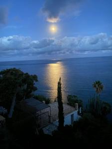 a full moon rising over the ocean at dusk at El jardin Botánico Villa LUZ in Altea