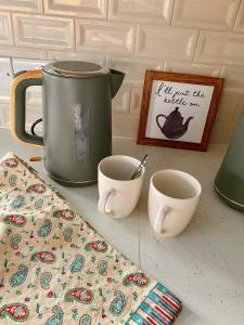 uma mesa com um bule de chá e duas xícaras sobre ele em NEW - The Gate Lodge at Dunnanew - 4 star- Sleeps 5 em Seaforde