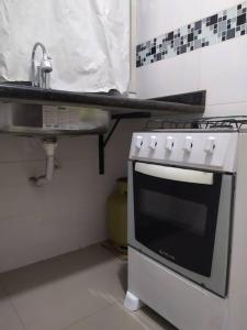 a kitchen with a sink and a stove at Quitinete para casal in Brasília