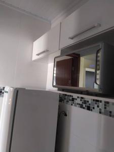 a kitchen with a microwave above a kitchen cabinets at Quitinete para casal in Brasília