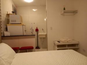 una piccola camera con letto e lavandino di Suíte Studio 3 Enseada Tortuga Mobiliada a Guarujá