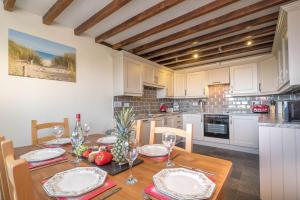 a kitchen with a wooden table and a dining room at Granar-Soch in Abersoch