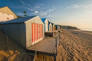 a row of colorful beach huts on the beach at Granar-Soch in Abersoch