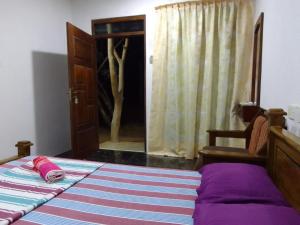 a bedroom with a bed and a door with a mirror at Wilpattu Buma Homestay in Pahala Maragahawewa