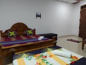 a bedroom with a wooden bed with colorful pillows at Wilpattu national park forest buma lodge in Pahala Maragahawewa