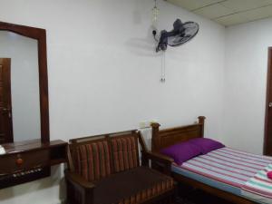 1 dormitorio con 1 cama y reloj en la pared en Wilpattu Buma Homestay, en Pahala Maragahawewa