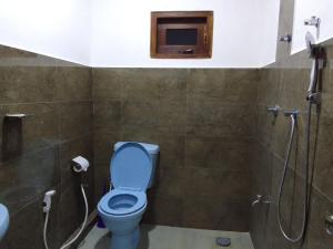 a bathroom with a blue toilet and a shower at Wilpattu Buma Homestay in Pahala Maragahawewa