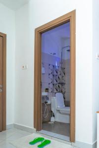 baño con aseo y puerta de cristal en Angani Apartment, AC Installed, Ocean View & Rooftop Pool, en Mombasa