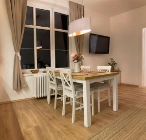 a dining room with a table and chairs and a window at Andy Apartmán Jáchymov in Jáchymov +7 photos