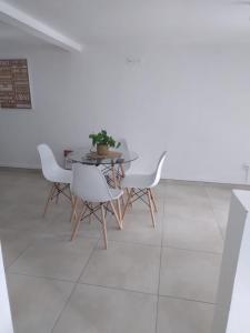 Un comedor con una mesa y sillas blancas. en les lau, en Sainte-Anne