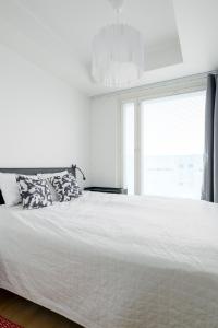 a white bed with pillows in a bedroom with a window at New LUXUS 3BR Helsinki Home in Helsinki