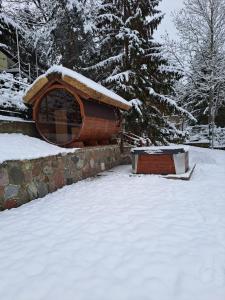 une cabane en rondins avec un toit enneigé dans une cour dans l'établissement Dom nad jeziorem Ublik z sauną i jacuzzi, à Ublik